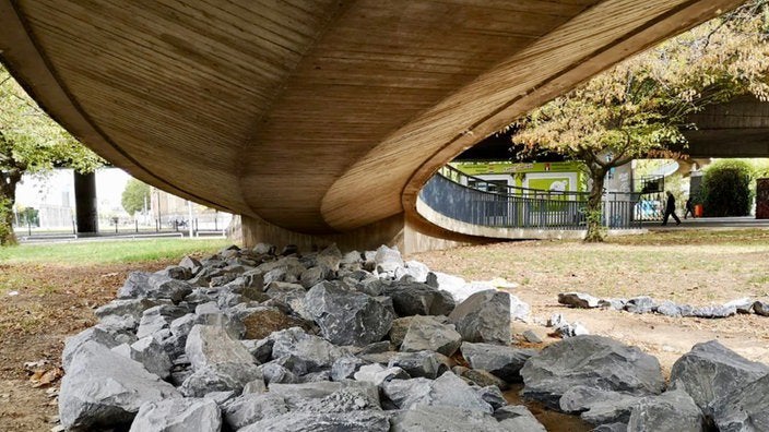 An example of anti-homeless Architecture. Boulders placed underneath a walking bridge to prevent people from squatting. 
