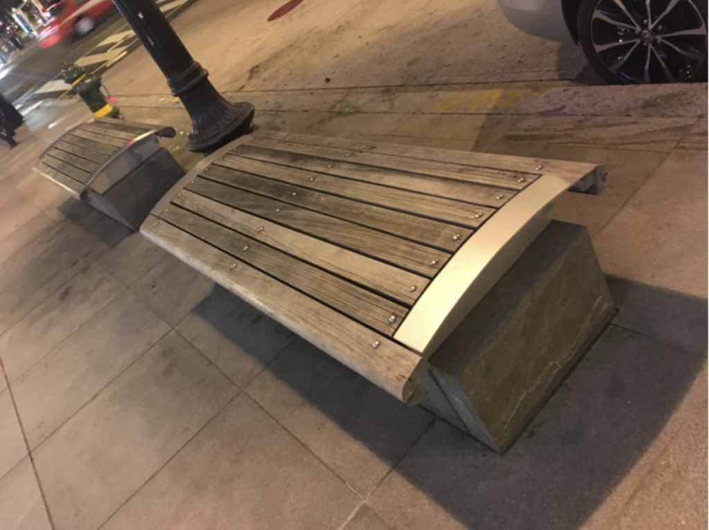 Curved bench to prevent someone from comfortably sitting or laying down on it for a long period of time. 