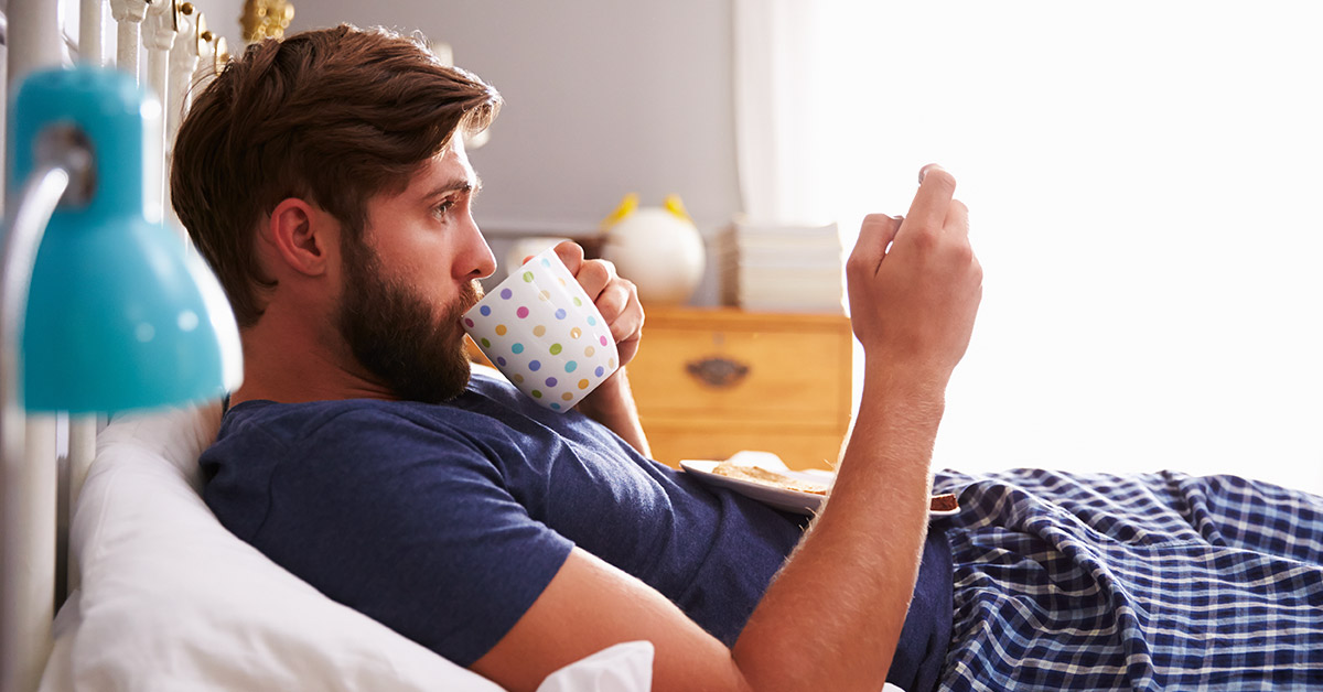 phone removed from picture of man in bed sipping coffee