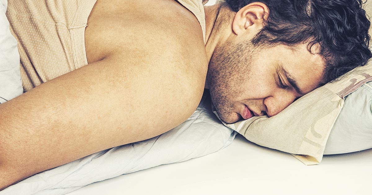 man sleeping in bed on pillow