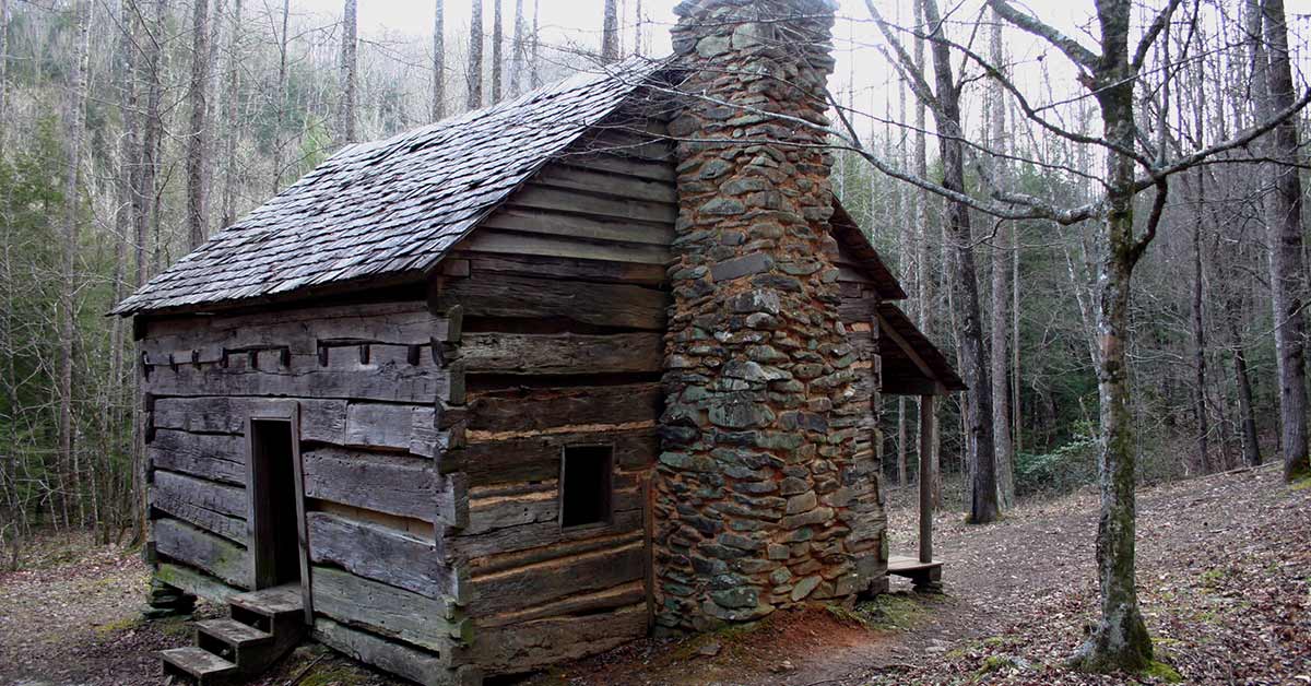 wooden cabin with a stone chimney