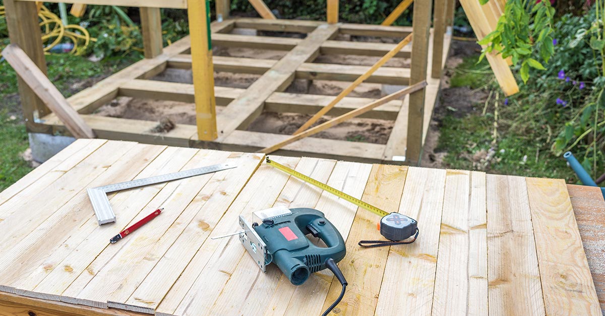 tools placed on a wooden floor amidst the construction of a cabin