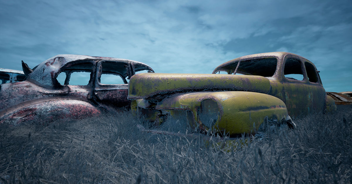 old deserted cars in a grassy feild