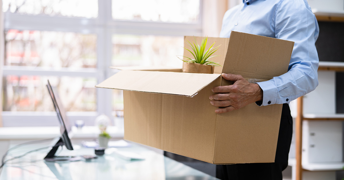 employee leaving with belongings in cardboard box after quitting job