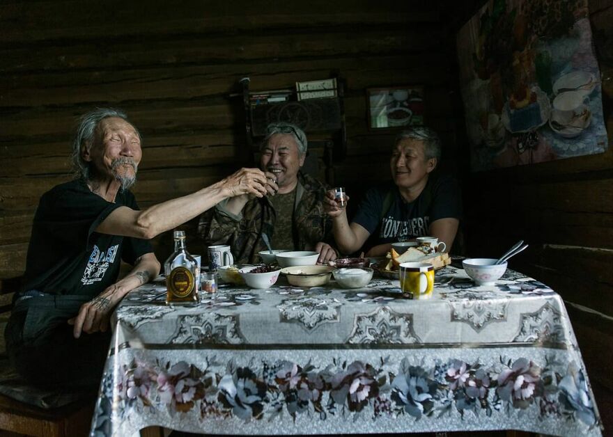 3 men eating and drinking together. Photo by Aleksey Vasiliev