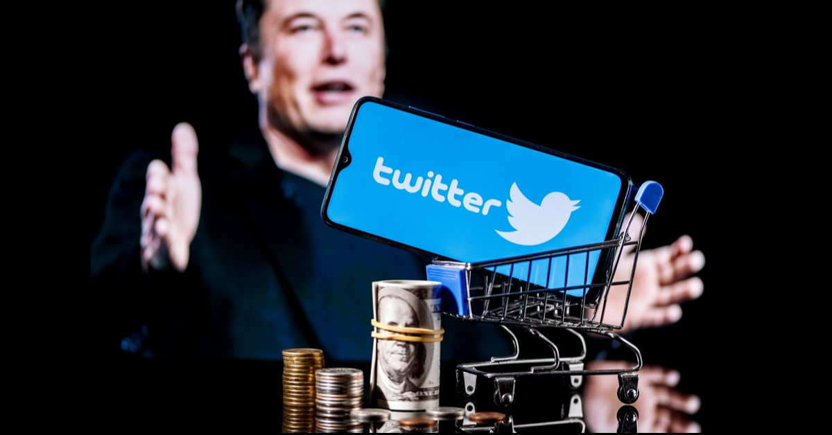 Elon Musk in the background with a model shopping card holding a smartphone displaying the Twitter logo. Money including bills and coins are at the base of the cart.